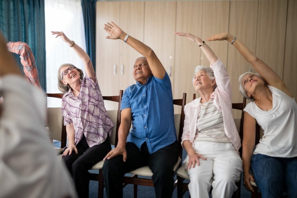 chair exercises for seniors 4 week plan tracker on a table with a pen and simple home workout tools